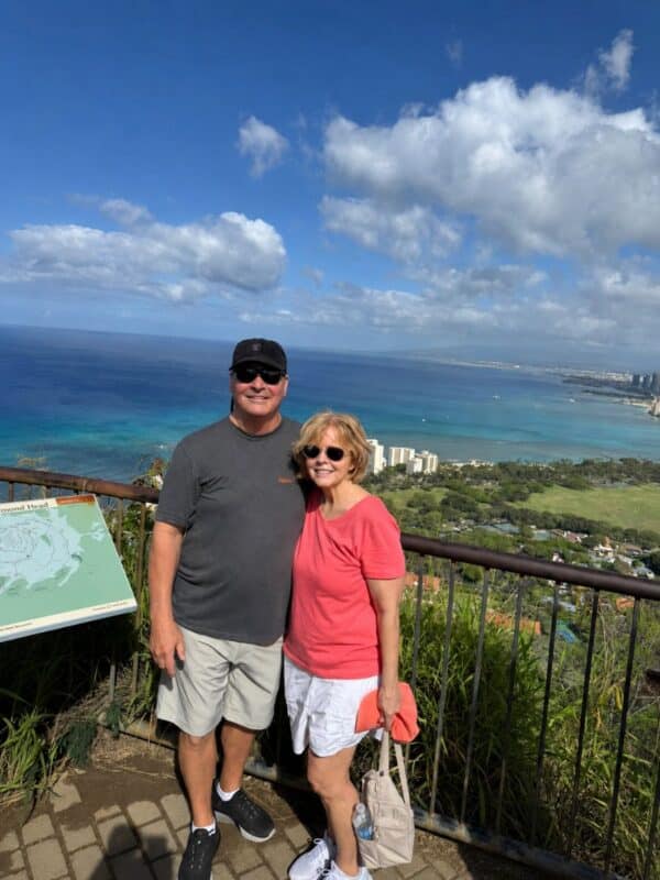 Couple at top of Diamond Head with ocean view of Waikiki Oahu in background