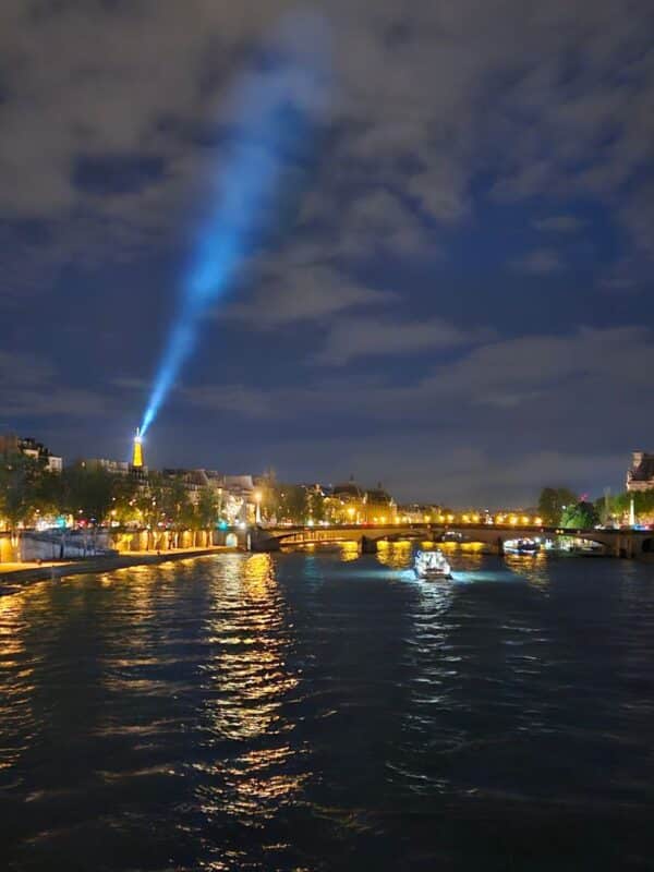 Eiffel Tower sparkling at night in Paris view from the river