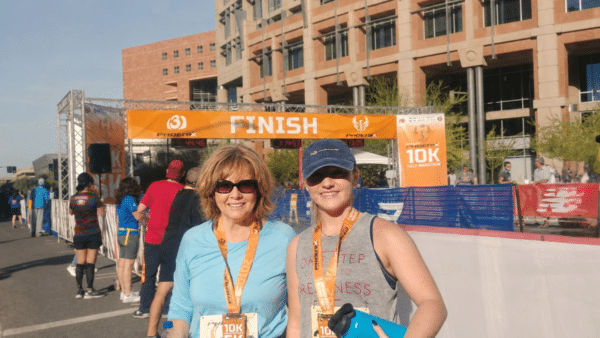 Two runners with 5K medals at the Phoenix race finish line